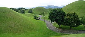 Rolling green hills with a road in between.