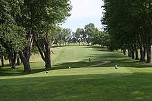 Golf course with fairway running through trees