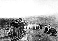 Oddíl rakousko-uherských vojáků popravují klečící Srby.