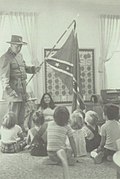 mad with flag surrounded by children
