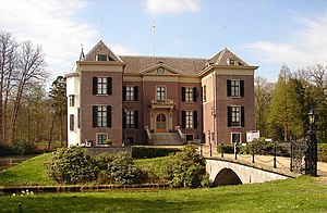 Red brick front of the building with a stone bridge leading to the entrance