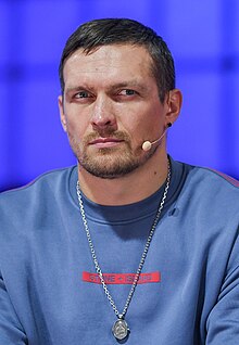 Oleksandr Usyk seated, wearing a microphone