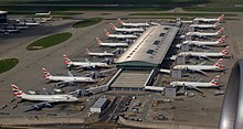 Planes congregate by a building.