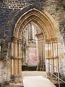 Porte de l'abbatiale en ruine donnant sur le cloître.