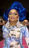 Photograph of a drag performer wearing a blue wig