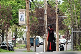 Man in a cosplay-style outfit smokes a cigarette outside Passano Paints.jpg