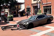 Silver gray late model compact car in an intersection dragging its front bumper area