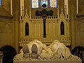 Tomb with effigies of Emperor Pedro II of Brazil and his wife Teresa Cristina in the Cathedral of Petrópolis, Brazil. In the background, an altar crucifix. The cross is made of black granite from Tijuca forest.[37]