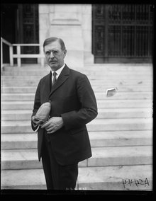 Old picture of the Professor Saville holding an archaeological artefact in his hands.