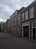 Koetshuis met versierde deur en vensteromlijstingen van Prinsessegracht 29