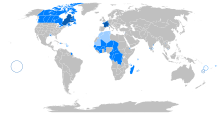 Grafische Weltkarte mit farbig markierten Ländern, in denen Französisch gesprochen wird. Kleine Regionen und Inseln sind eingekreist.