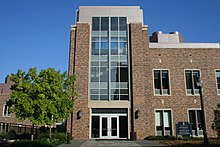 A four-story brick and stone building alongside pedestrian path