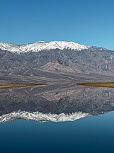 Snow-capped mountains reflecting in the lake in the basin