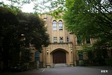 Light-colored building, with trees in front