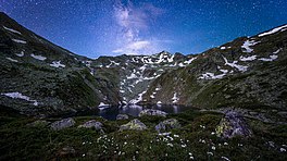 Jazhincë Lake at night, with Milky Way Galaxy background.