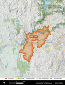 The 49er Fire footprint is shown in vivid orange, originating near Highway 49 and spreading down and to the left towards multiple towns against a white and green backdrop