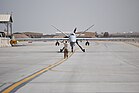 Ein Reaper UAV wird am 20. März 2014 von einem U.S. Airman als Marshaller auf dem Flughafen Kandahar eingewiesen. Neben der US Air Force wird dieses UAV auch von der Royal Air Force, der Armée de l’air, der Koninklijke Luchtmacht, der Aeronautica Militare und anderen eingesetzt. KW 15 (ab 6. April 2014)