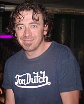 Benny Benassi olhando para a câmera e sorrindo.