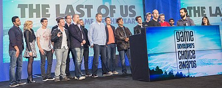 A group of 19 people accepting an award on a stage