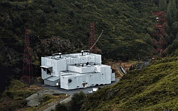 Transmitter building. From the two bushings on the roof cables supply power to two feed buses which extend both directions along the valley, connected to the overhead antenna wires.