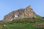 A mountain above a forest, a museum building at the side of the mountain