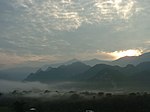 Sunset or sunrise ower a moontain landscape wi fog in the valleys.