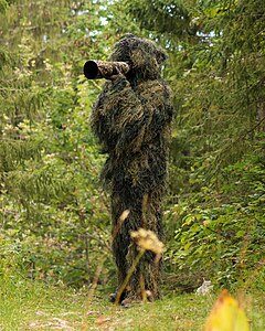 Wildlife photographer in a ghillie suit, by Giles Laurent