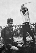Photo d'une exécution : un Japonais est sur le point de couper la tête d'un prisonnier, à genou devant lui et les yeux bandés.