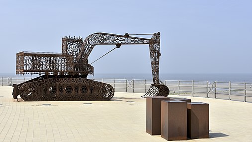 Sculpture d'un homme doré chevauchant une tortue géante et également dorée