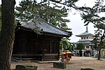 Large stones set in the ground in front of temple buildings.