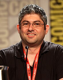 Goldstein smiling, seated behind a microphone