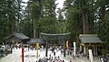 View looking back from top of first set of stairs. The bronze torii is flanked by a minor building to the left and beyond it the sacred stable, and the Suibansha on the right. Out of sight to the left are the storehouses: Kamijinko, and beyond it, Nakajinko and Shimojinko. Out of sight to the right is the Kyōzō.