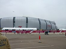 photo of State Farm Stadium taken from the parking lot, showing the domed stadium against an overcast sky