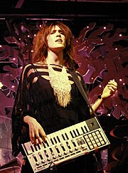 A woman holding a MIDI keyboard