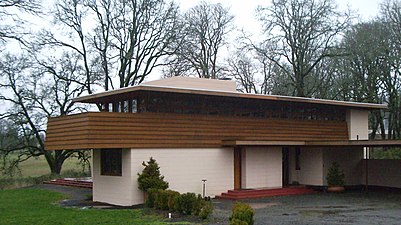 Main entrance near carport is door at right; the left service door enters between kitchen and laundry