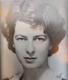 "Black and white photograph of a young woman with dark wavy hair looking right at the camera"