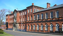 Photo of a three story rectangular red brick building