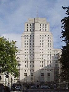 A white stone skyscraper tower with numerous small windows