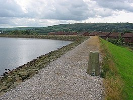 A dam head with houses beyond