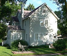 Two-story half-timbered house; statue of Norris seated on park bench in front