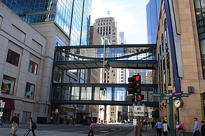 Rue américaine de centre-ville franchie par deux niveaux de passerelles, respectivement aux premier e troisième étages.