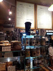 Photograph of a cafe interior with a menu and a display case