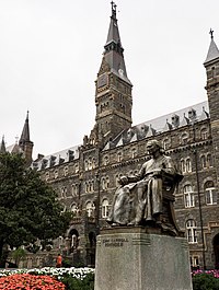 Photograph looking up at Bishop John Carroll with the Healy Hall clocktower in the background