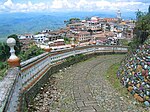 A look at the city from above along a descending path with a decorated fence