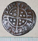 dull, silver coin with a cross in the centre