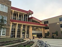 Front entrance of the school, featuring a three-story glass facade between two brick structures