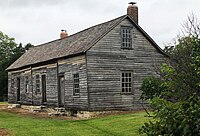 Wooden rectangular building with angled roof and chimneys