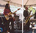 Musicians playing bass guitar, drums, and saxophone