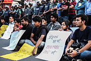 Seated protesters, holding placards