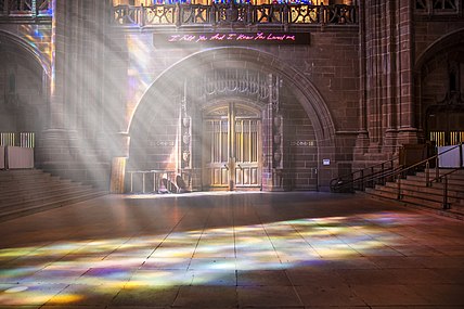 néon rose indiquant « I felt you and I know you loved me » au-dessus de la porte d'une cathédrale